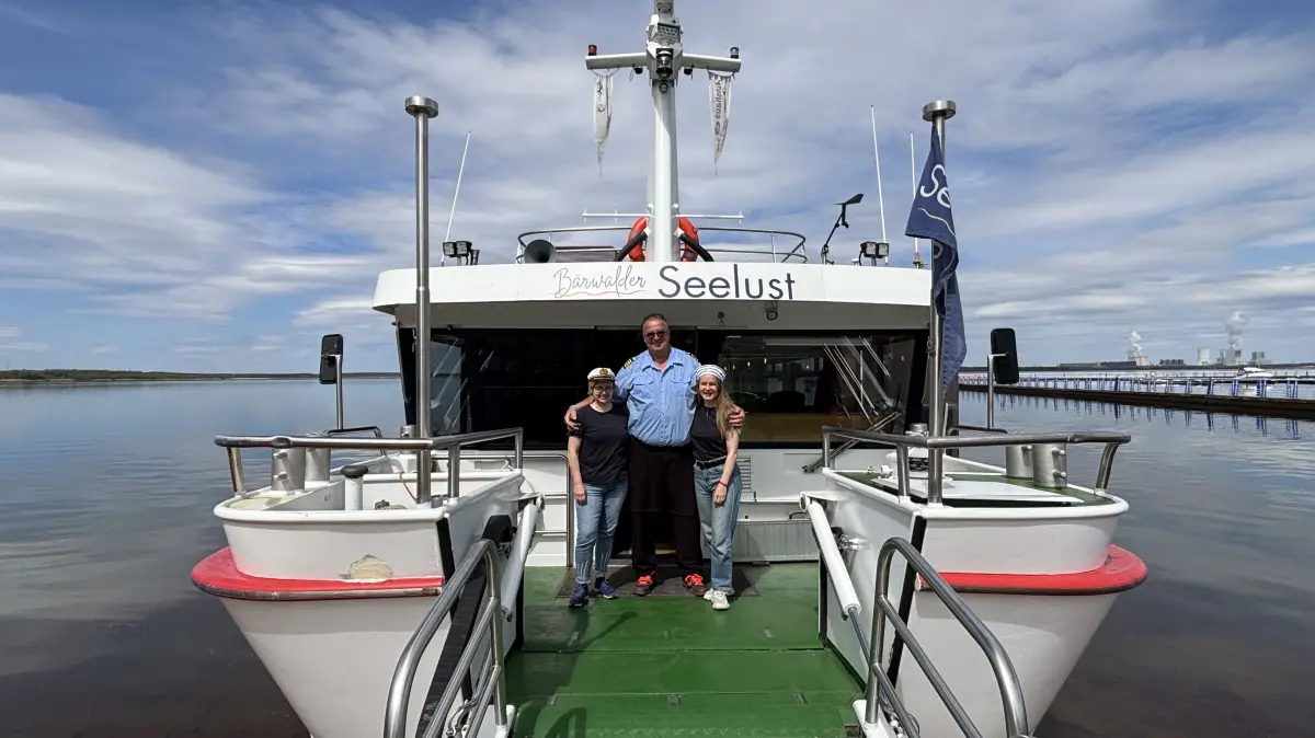 Das Motorschiff Bärwalder Seelust am Hafen in Klitten. Hier legt das Schiff an gleich neben dem Hafen in Klitten. Madlen Hanusch, Axel Löffler und Joanna Dźwiga (v.l.n.r.) gehören zur Crew und sind regelmäßig im Einsatz.