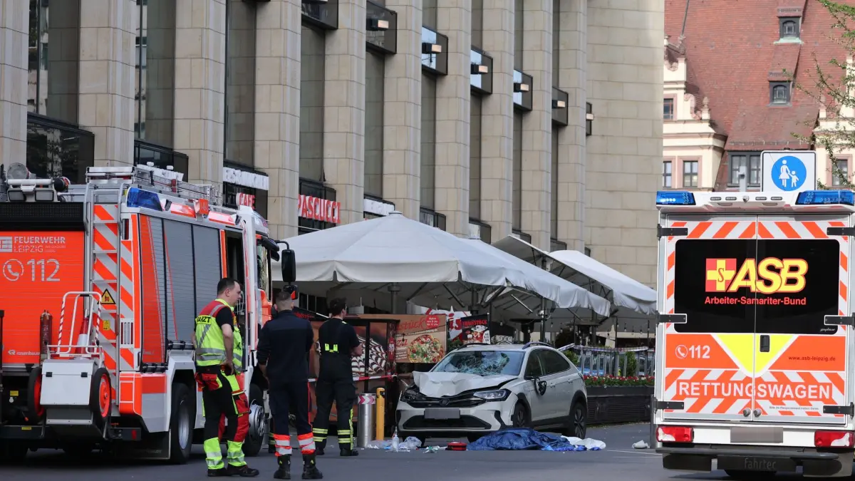 Auto in Leipzig in Menschengruppe gefahren: 04.05.2026, Sachsen, Leipzig: Rettungskräfte stehen in der Nähe eines beschädigten Autos an der Stelle, wo ein Auto in eine Menschengruppe gefahren ist. Foto: Jan Woitas/dpa +++ dpa-Bildfunk +++