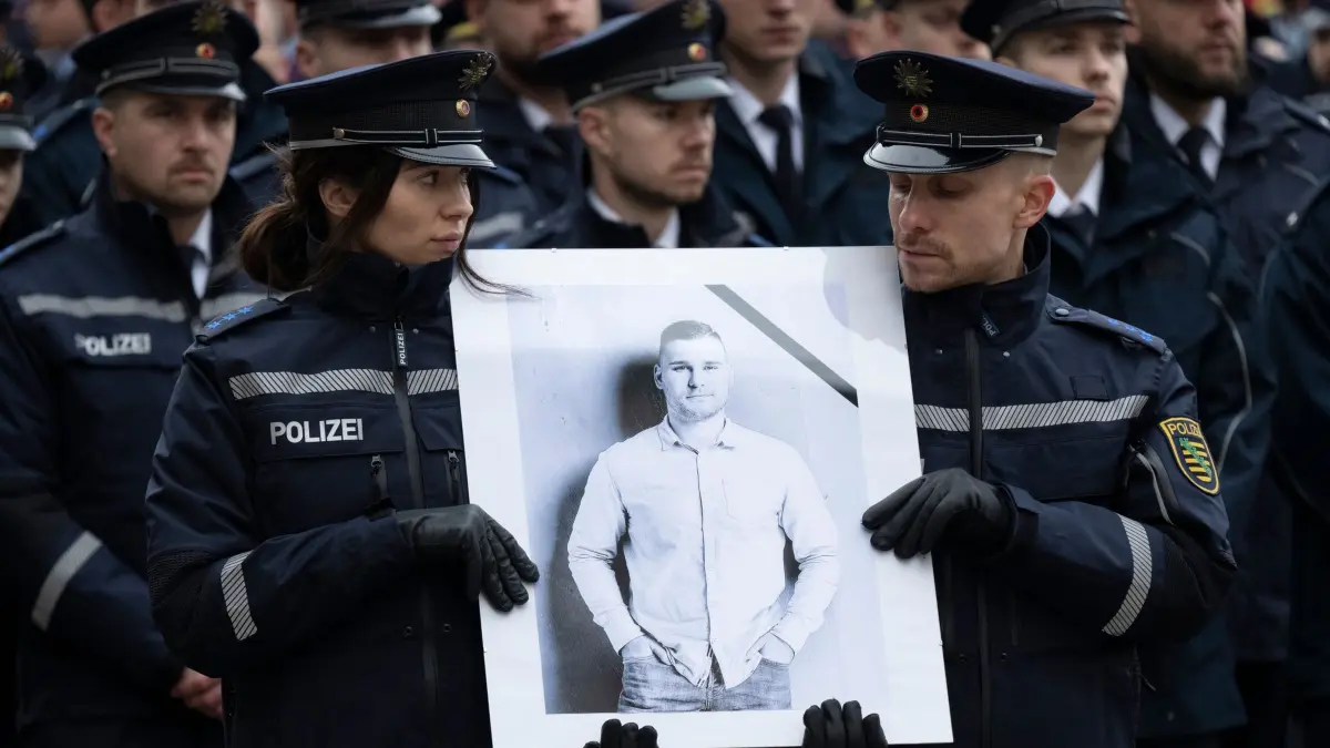 Gedenkgottesdienst für getöteten Polizisten aus Sachsen: ARCHIV - 28.01.2025, Sachsen, Dresden: Polizisten tragen vor Beginn eines Gedenkgottesdienst der sächsischen Polizei für den vor drei Wochen im Dienst getöteten Polizisten Maximilian Stoppa ein Porträt. Der 32 Jahre alte Beamte kam am 7. Januar 2025 in Lauchhammer ums Leben, als er bei der Fahndung nach mutmaßlichen Autodieben ein verdächtiges Fahrzeug kontrollieren wollte. (zu dpa: «Getöteter Polizist: Angeklagter wegen Autorennens verurteilt») Foto: Sebastian Kahnert/dpa - ACHTUNG: Nur zur redaktionellen Verwendung im Zusammenhang mit der aktuellen Berichterstattung und nur mit vollständiger Nennung des vorstehenden Credits +++ dpa-Bildfunk +++