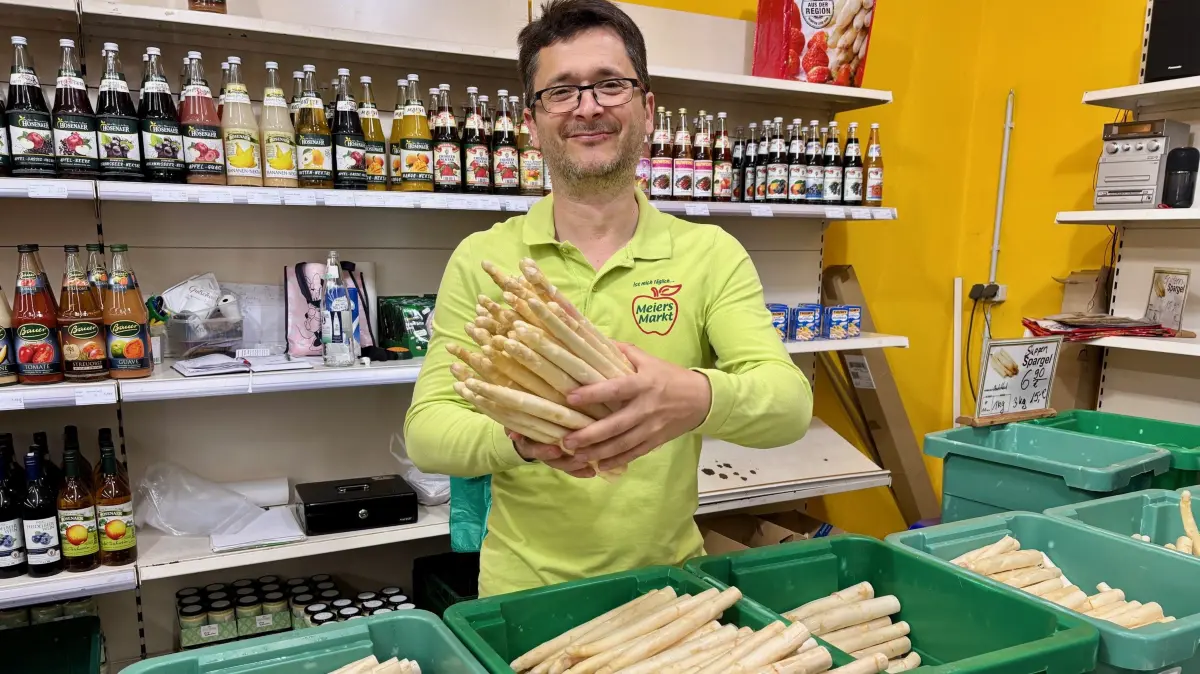 Henri Meier hält frischen Spargel in der Hand auf seinem Obsthof Meier in Klein Gaglow. Er hofft, dass nach dem Regen jetzt wieder Sonne kommt. Denn die Wärme braucht der Spargel zum Wachsen.
