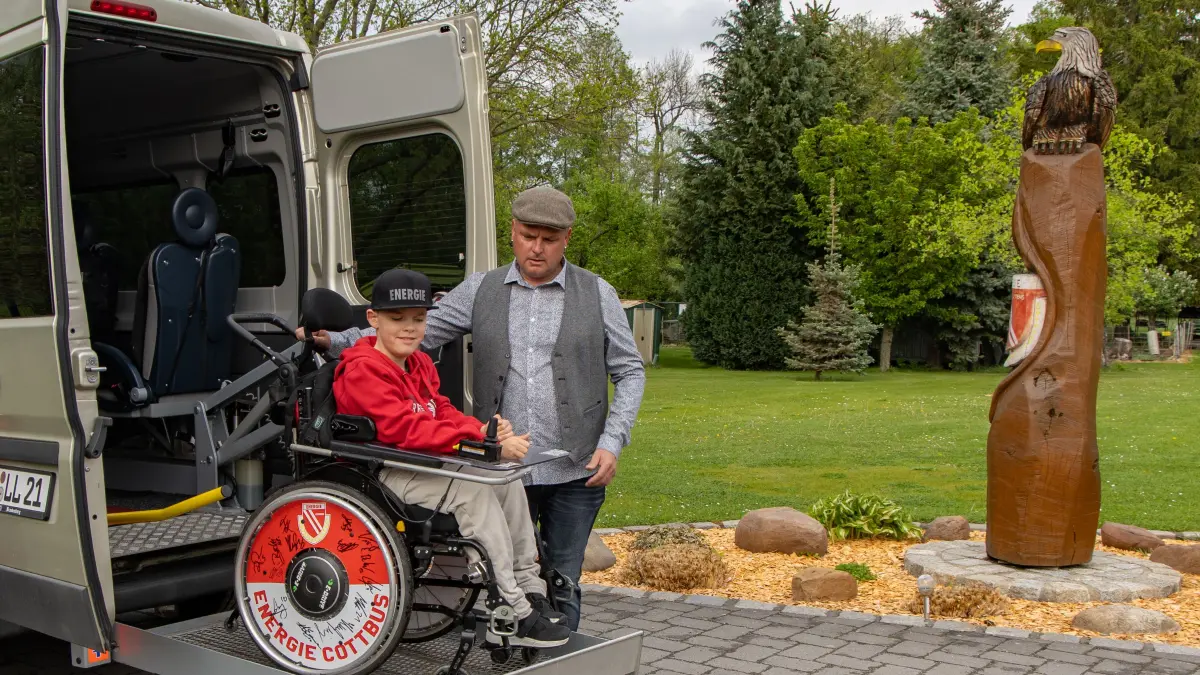 Steffen Radehose demonstriert mit Sohn Lino die elektrische Hebebühne am Bus.