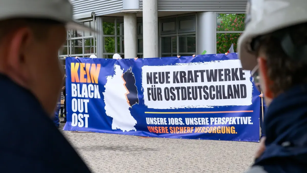 Protest in der Lausitz - Sorge um neue Gaskraftwerke wächst: 08.05.2026, Brandenburg, Schwarze Pumpe: Auszubildende vom Energiekonzern Leag stehen mit einem Transparent mit der Aufschrift «Kein Blackout Ost - Neue Kraftwerke für Ostdeutschland» auf der Kundgebung «Milliarden für den Süden, leere Versprechen für den Osten» vor dem Braunkohlekraftwerk Schwarze Pumpe. Der Energiekonzern Leag sieht die Lausitz bei neuen Gaskraftwerken benachteiligt. Ein Gesetzentwurf sieht vor, dass rund zwei Drittel neuer Kraftwerkskapazitäten in ersten Ausschreibungsrunden in den sogenannten «netztechnischen Süden» gelenkt werden. Foto: Patrick Pleul/dpa +++ dpa-Bildfunk +++