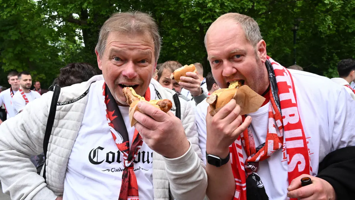 FCE Wehen Wiesbaden: Vorher noch bei einer Bratwurst stärken: Ulf Richter aus Plessa (l.) und Andreas Juhrsch aus Haida.
Letztes Heimspiel des FC Energie Cottbus gegen den FC Wehen Wiesbaden und Kampf um einen Aufstiegsplatz am Sonnabend, 9. Mai 2026, im ausverkauften LEAG Stadion der Freundschaft.