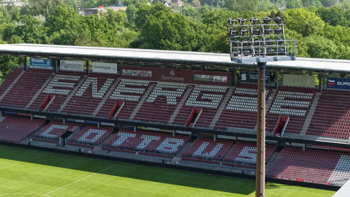 Luft FCE Leag Stadion: Luftaufnahme vom 10. Mai 2026
Blick auf das Leag Energie Stadion der Freundschaft
Brandenburgs Sportminister Gordon Hoffmann hat am Sonnabend, 9. Mai 2026, dem FC Energie Cottbus die Landesförderung zur Modernisierung des LEAG Energie Stadions überbracht.
Mit dem Zuwendungsbescheid erhält der FC Energie Cottbus eine Förderung über 1,67 Millionen Euro und damit den größten Teil der zugesicherten zwei Millionen Euro Landesförderung. Mit dem weiterhin noch zur Verfügung stehenden Restbetrag kann der Verein flexibel auf weitere Modernisierungserfordernisse reagieren, die erst im Zuge des Lizenzierungsverfahren für die 2. Bundesliga deutlich werden sollten. Im Vordergrund der Förderung stehen die Modernisierungen der Flutlichtanlage, der Infrastruktur für die mediale Übertragung, Verbesserungen im Besucherbereich sowie der Umbau einer Sporthalle für den Trainingsbetrieb. Die Gesamtinvestitionskosten belaufen sich auf knapp 2,1 Millionen Euro.