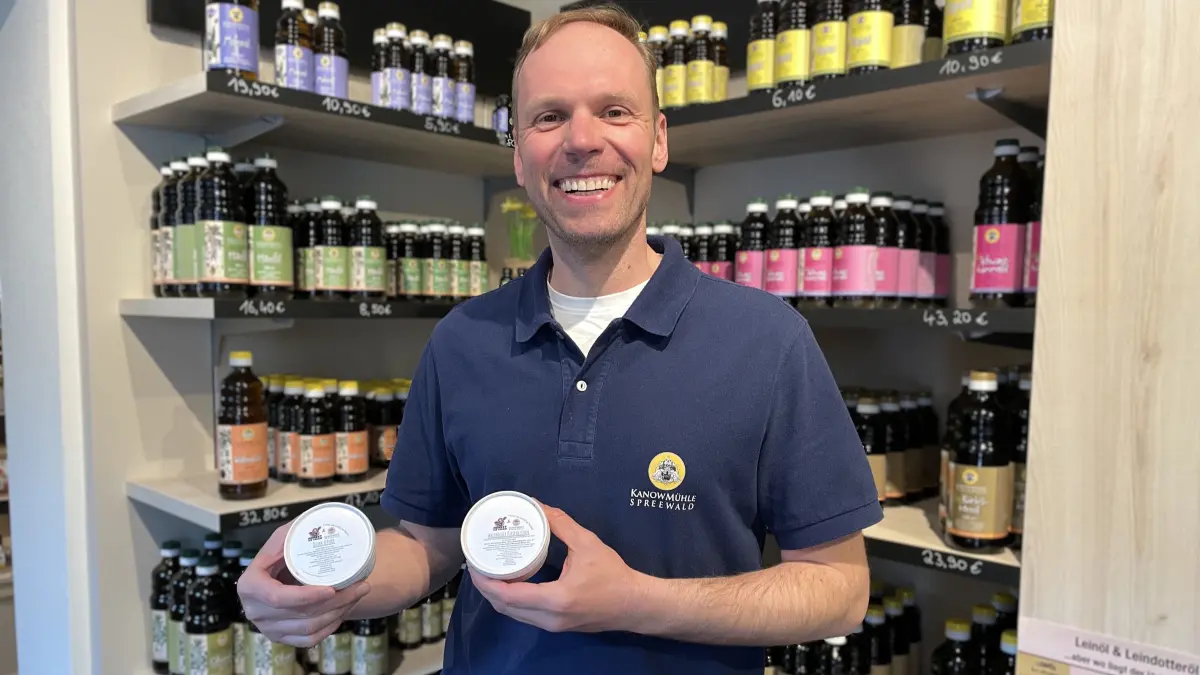 Christian Behrendt, Chef der Kanow Mühle in Sagritz, hält am 8.5.2026 zwei Becher Eis im Hofladen in die Kamera.