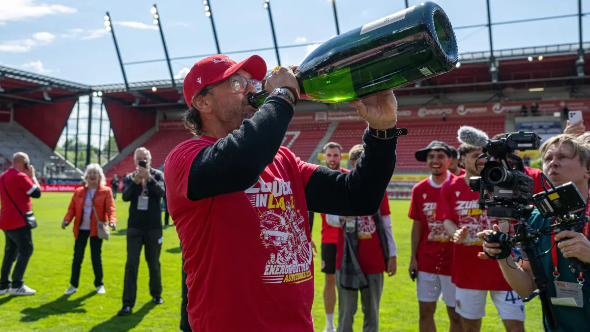 3. Liga Jahn Regensburg - Energie Cottbus 2025/26: Fussball, Herren, Saison 2025/2026, 3. Liga (38. Spieltag), SSV Jahn Regensburg - FC Energie Cottbus, Trainer Claus-Dieter Pele Wollitz (Energie Cottbus), Jubel nach Abpfiff mit Champagner, 16.05. 2026, Foto: Sebastian Räppold / Matthias Koch