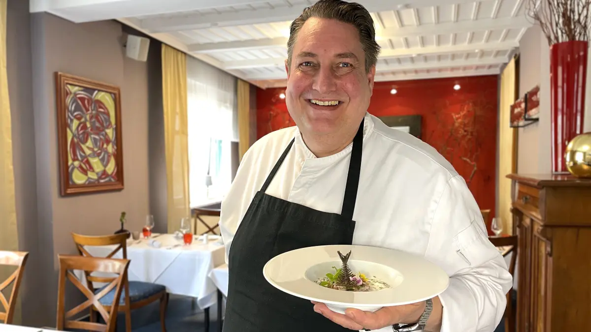 Frank Schreiber mit einem Teller Karpfentartar am 6.5.2026 im Gastraum seines Restaurants Goldener Hahn in Finsterwalde.