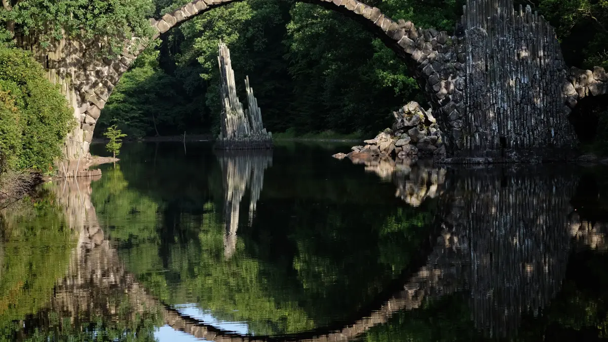 Die Rakotzbrücke im Azaleen- und Rhododendronpark von Kromlau spiegelt sich im Wasser. (zu dpa «Wiederaufbau der eingestürzten Rakotz-Grotte: 3D-Puzzle mit Steinen») +++ dpa-Bildfunk +++
