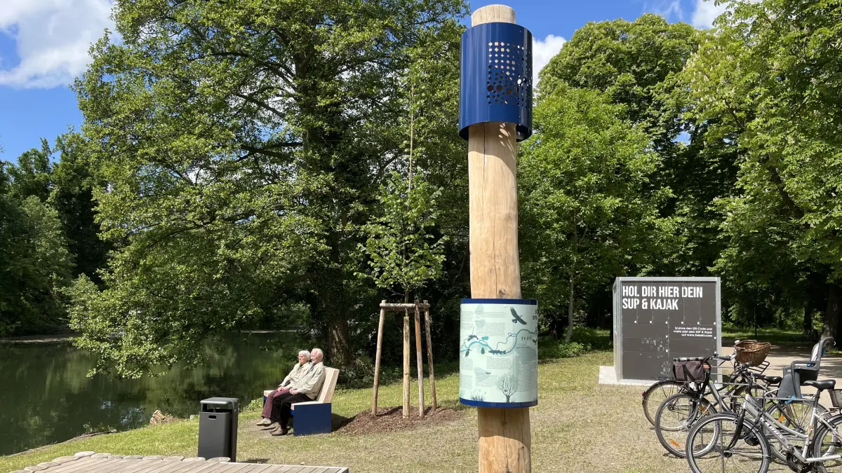 Spaziergänger probieren die neue Bank bei der SUP- und Kajakverleihstation an der Spree aus.