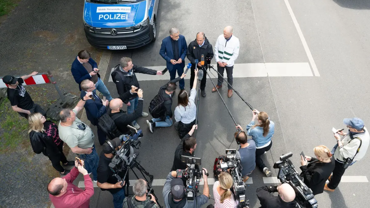 Hauseinsturz in Görlitz: 19.05.2026, Sachsen, Görlitz: Armin Schuster (l-r), Innenminister von Sachsen, Octavian Ursu, Oberbürgermeister von Görlitz, und Stephan Meyer (alle CDU), Landrat Landkreis Görlitz, sprechen auf einer Pressekonferenz unweit des eingestürzten Wohnhauses in der Innenstadt. Das Haus aus der Gründerzeit war am Vorabend eingestürzt, Retter suchen noch nach Vermissten. Als Ursache wird eine Gasexplosion vermutet. Foto: Sebastian Kahnert/dpa +++ dpa-Bildfunk +++