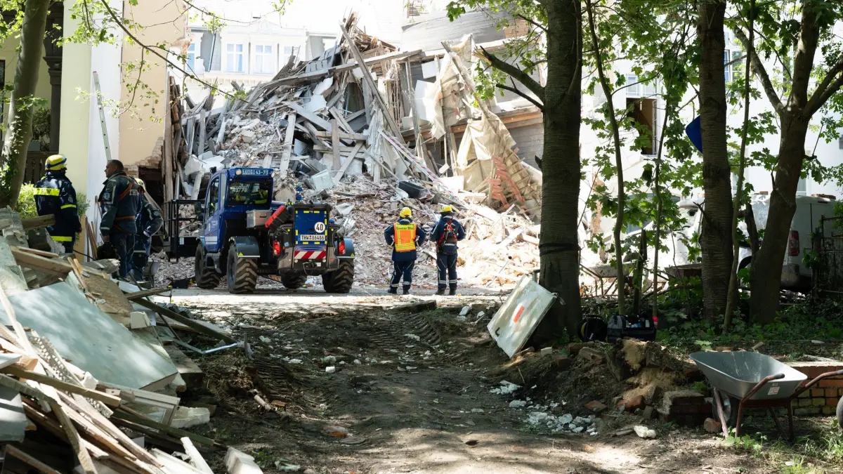 Hauseinsturz in Görlitz: 19.05.2026, Sachsen, Görlitz: Einsatzkräfte des Technischen Hilfswerks (THW) stehen vor dem Schuttberg des eingestürzten Wohnhauses in der Innenstadt. Das Haus aus der Gründerzeit war am Vorabend eingestürzt, Retter suchen noch nach Vermissten. Als Ursache wird eine Gasexplosion vermutet. Foto: Sebastian Kahnert/dpa +++ dpa-Bildfunk +++