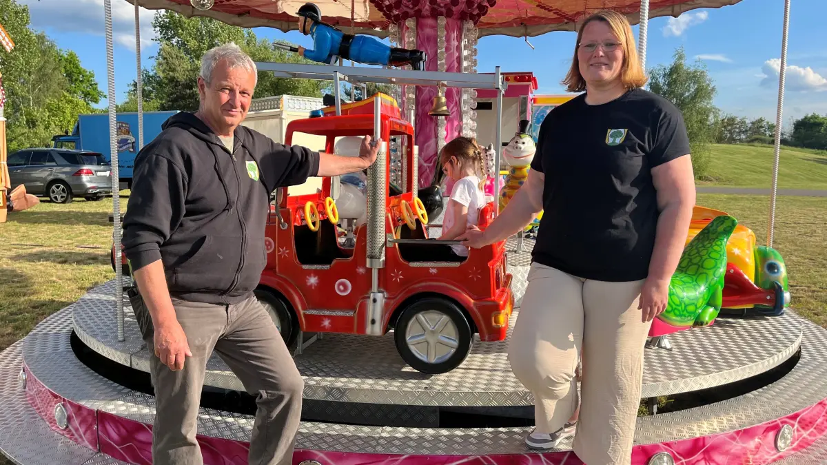 Die Vorsitzenden Tilo Schreier und Kristina Bergelt auf der Festwiese, auf der das Kinderkarussell bereits aufgebaut ist.