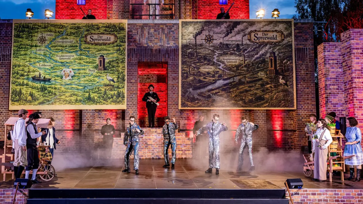 Generalprobe Spreewälder Sagennacht: 22.05.2026, Brandenburg, Burg (Spreewald): Schauspielerinnen und Tänzerinnen des Sorbischen National-Ensemble stehen bei der Generalprobe des Stückes «Müschen impossible, oder Wanka, Janek und die drei Unmöglichkeiten» auf der Freilichtbühne am Bismarckturm. Im Mittelpunkt der inzwischen 17. Auflage der Sagennacht steht Wanka, die nicht zulassen will, dass ihre Heimat zerstört wird. Denn der superreiche Unternehmer Dieterich Muks möchte den Spreewald einebnen, um eine riesengroße Fabrik zu errichten. Mit dieser Nachricht platzt er in das fröhliche Müschener Erntedankfest. Was die Menschen zuerst für einen Scherz halten, ist bitterer Ernst. Als sich die Menge dagegen auflehnt, lässt Muks keinen Zweifel daran, dass er seinen Plan mit aller Macht durchsetzen will. Foto: Frank Hammerschmidt/dpa +++ dpa-Bildfunk +++