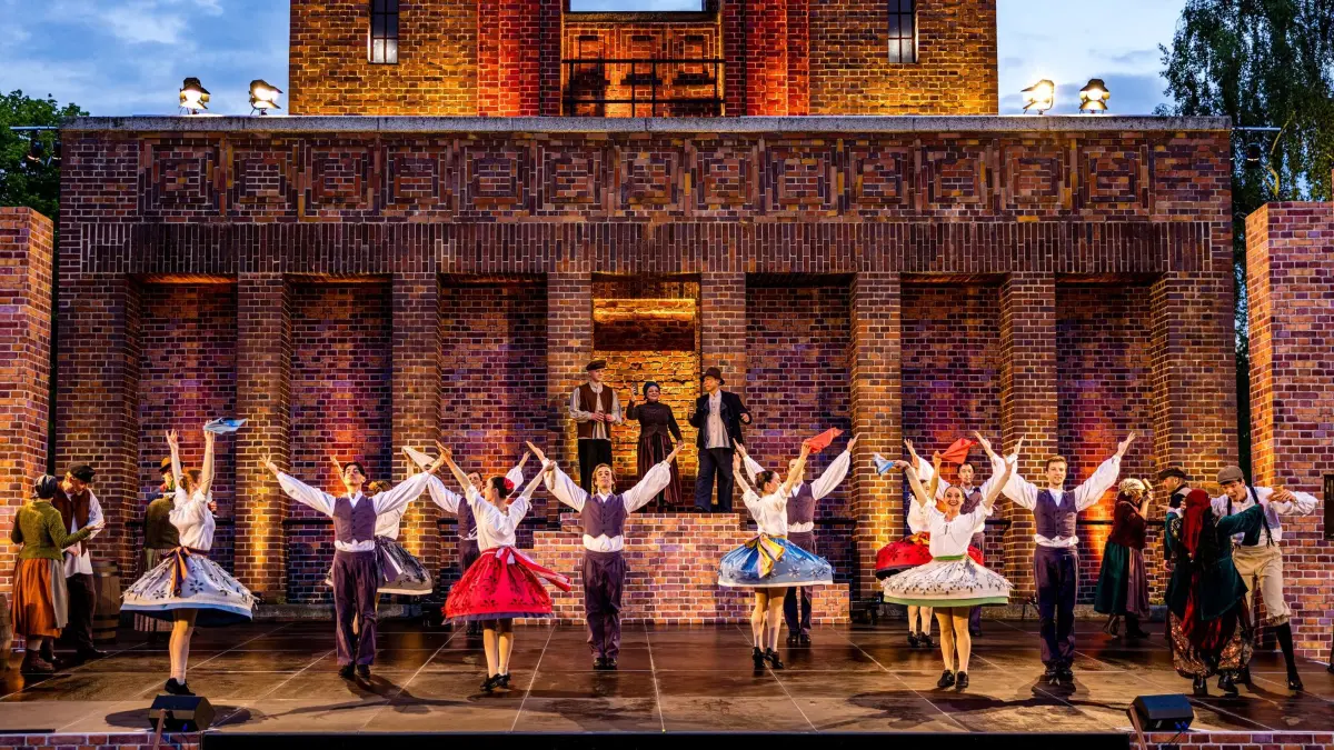Generalprobe Spreewälder Sagennacht: 22.05.2026, Brandenburg, Burg (Spreewald): Schauspielerinnen und Tänzerinnen des Sorbischen National-Ensemble stehen bei der Generalprobe des Stückes «Müschen impossible, oder Wanka, Janek und die drei Unmöglichkeiten» auf der Freilichtbühne am Bismarckturm. Im Mittelpunkt der inzwischen 17. Auflage der Sagennacht steht Wanka, die nicht zulassen will, dass ihre Heimat zerstört wird. Denn der superreiche Unternehmer Dieterich Muks möchte den Spreewald einebnen, um eine riesengroße Fabrik zu errichten. Mit dieser Nachricht platzt er in das fröhliche Müschener Erntedankfest. Was die Menschen zuerst für einen Scherz halten, ist bitterer Ernst. Als sich die Menge dagegen auflehnt, lässt Muks keinen Zweifel daran, dass er seinen Plan mit aller Macht durchsetzen will. Foto: Frank Hammerschmidt/dpa +++ dpa-Bildfunk +++