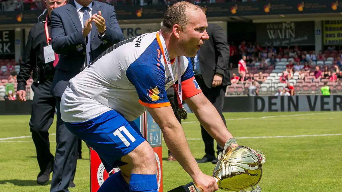 Landespokal Brandenburg - 2025/2026 - Finale - FC Energie Cottbus gegen VfB Krieschow: Cottbus, Deutschland 23. Mai 2026:
Landespokal Brandenburg - 2025/2026 - Finale - FC Energie Cottbus gegen VfB Krieschow
Im Bild: Andy Hebler (VfB Krieschow) kommt mit dem Siegerpokal
/// DFB regulations prohibit any use of photographs as image sequences and/or quasi-video. ///