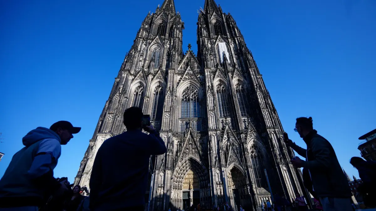Kölner Dom: ARCHIV - 05.03.2026, Nordrhein-Westfalen, Köln: Touristen fotografieren den Kölner Dom. (zu dpa: ««Tarifdschungel» Nahverkehr: Was ändert sich und was fehlt?») Foto: Henning Kaiser/dpa +++ dpa-Bildfunk +++