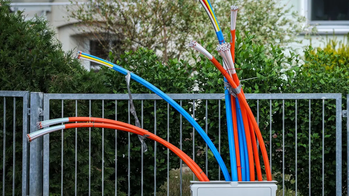 Glasfaserausbau: ARCHIV - 26.07.2023, Sachsen, Zwenkau: Aus dem Sockel eines Schaltschranks ragen Glasfaserkabel heraus. In Deutschlands Glasfaser-Branche kriselt es: Die Kosten sind hoch und die Einnahmen gering. (zu dpa: «Wenige Kunden, hohe Kosten: Es kriselt in Glasfaser-Branche») Foto: Jan Woitas/dpa +++ dpa-Bildfunk +++