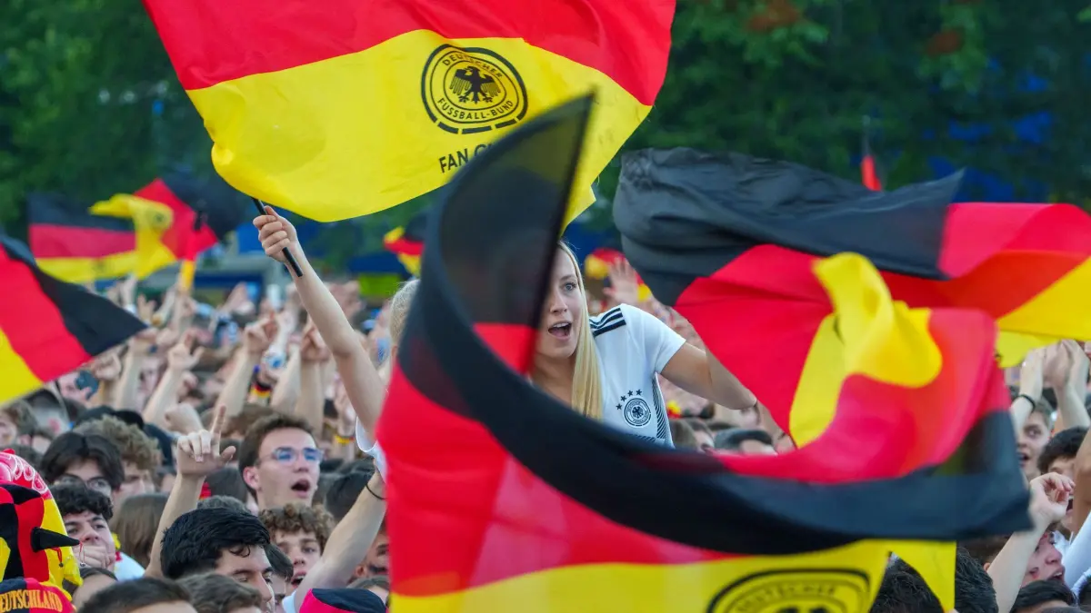 Euro 2024: Public Viewing Frankfurt/Main: ARCHIV - 23.06.2024, Hessen, Frankfurt/Main: Deutschlandfahnen werden beim Anpfiff der Partie Schweiz - Deutschland geschwenkt. Bei der Fußball-Europameisterschaft trifft die deutsche Nationalmannschaft heute auf die Schweiz in Frankfurt am Main. (zu dpa: «Wo schaut Hessen die Fußball-WM?») Foto: Andreas Arnold/dpa +++ dpa-Bildfunk +++