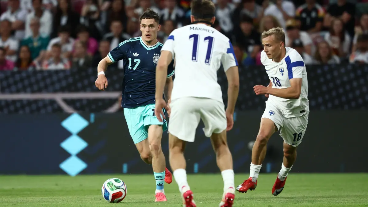 Florian Wirtz (l, Deutschland) kämpft hier gegen Finnlands Adam Markhiev (M, Finnland) und Topi Keskinen (Finnland) um den Ball.