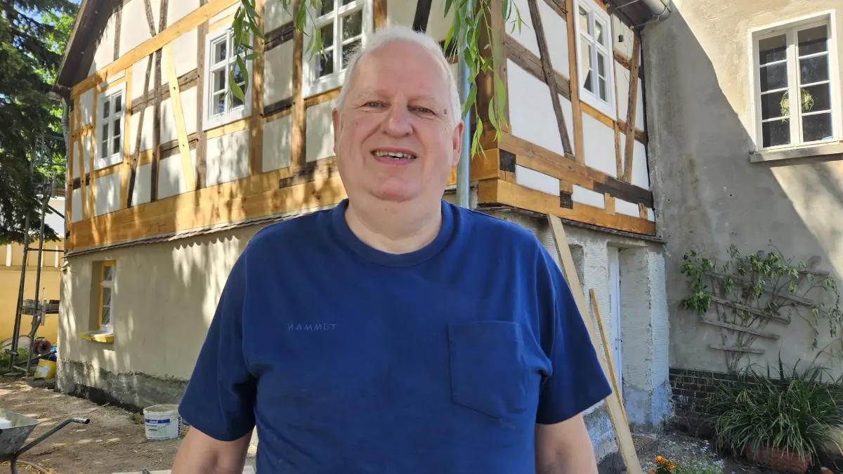 Aus der einsturzgefährdeten Ruine wird Schritt für Schritt wieder ein Schmuckstück: Vereinsvorsitzender Jörg Rommel vor der sanierten Fachwerkfassade der Schlossmühle in Lauchhammer-West.