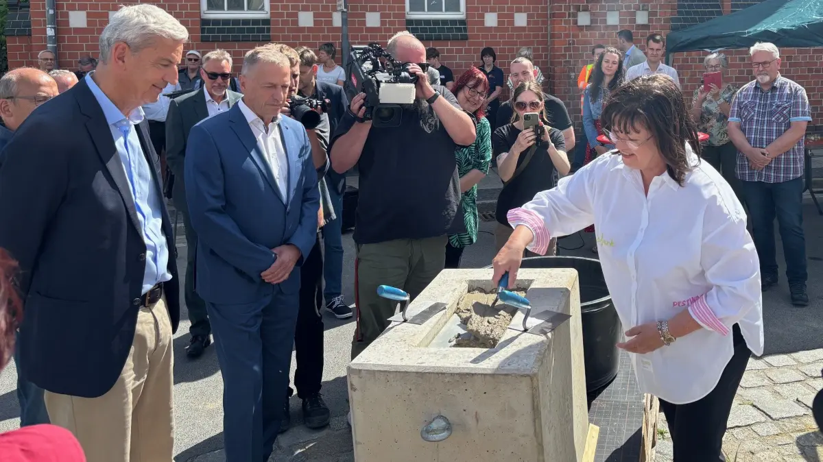 Bürgermeisterin Christine Herrentier (parteilos) mauert in Spremberg den Grundstein für den Erweiterungsbau an der Berufsorientierenden Oberschule ein. Architekt Christian Beck (links) und Rektor Roland Wolter flankieren. Das neue Gebäude nimmt drei Nutzungsarten auf.