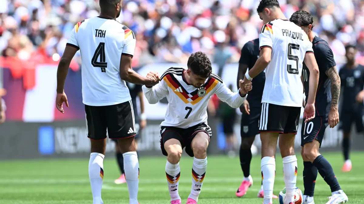 USA - Deutschland: 06.06.2026, USA, Chicago: Fußball, Männer, Nationalmannschaft, Vorbereitung auf die Fußball-WM 2026, Länderspiel, USA - Deutschland im Soldier Field. Jonathan Tah (l, Deutschland) und Aleksandar Pavlović (r, Deutschland) helfen Kai Havertz (Deutschland) aufzustehen. Foto: Federico Gambarini/dpa +++ dpa-Bildfunk +++