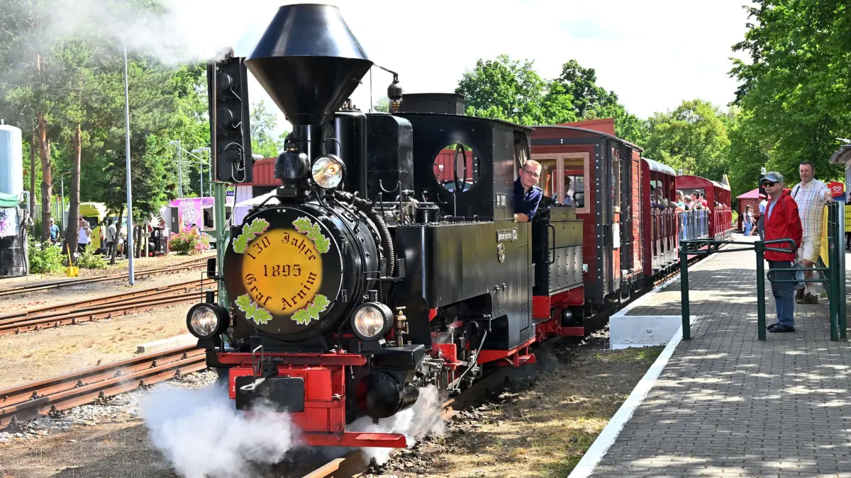 Parkeisenbahnfest Sandow 2026: Mit einem großen Kinder- und Familienfest ist am Samstag auf dem Bahnhof Sandower Dreieck der Internationale Kindertag nachgefeiert worden. Neben Auftritten des Cottbuser Kindermusicals, der Academy of Music und von Sänger Alexander Knappe sowie den Mädchen und Jungen von Femella Kindertanz gab es für die Besucherinnen und Besucher mit ihren Kindern und Enkeln auch die Möglichkeit, auf dem 3,2 Kilometer langen Rundkurs zwischen dem Bahnhof Sandower Dreieck und Park & Schloss Branitz eine Fahrt mit der Cottbuser Parkeisenbahn zu unternehmen. Besonders beliebt waren auch in diesem Jahr die Fahrten mit den von der 131 Jahre alten Dampflok „Graf Arnim“ angetriebenen Zügen. Die Maskottchen Paul Frosch, das Maskottchen von Cottbusverkehr und das Sandmännchen von Antenne Brandenburg waren ebenfalls dabei, ebenso wie die Cottbuser Verkehrswacht mit einem Hindernis-Parcour und einem Überschlagsimulator.