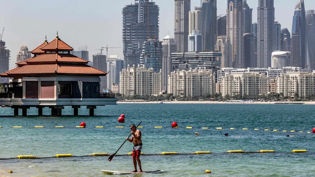 TOPSHOT - A man practices stand-up paddleboarding (SUP) along the beach at the Anantara The Palm Dubai Resort in Dubai on June 6, 2026. (Photo by FADEL SENNA / AFP)