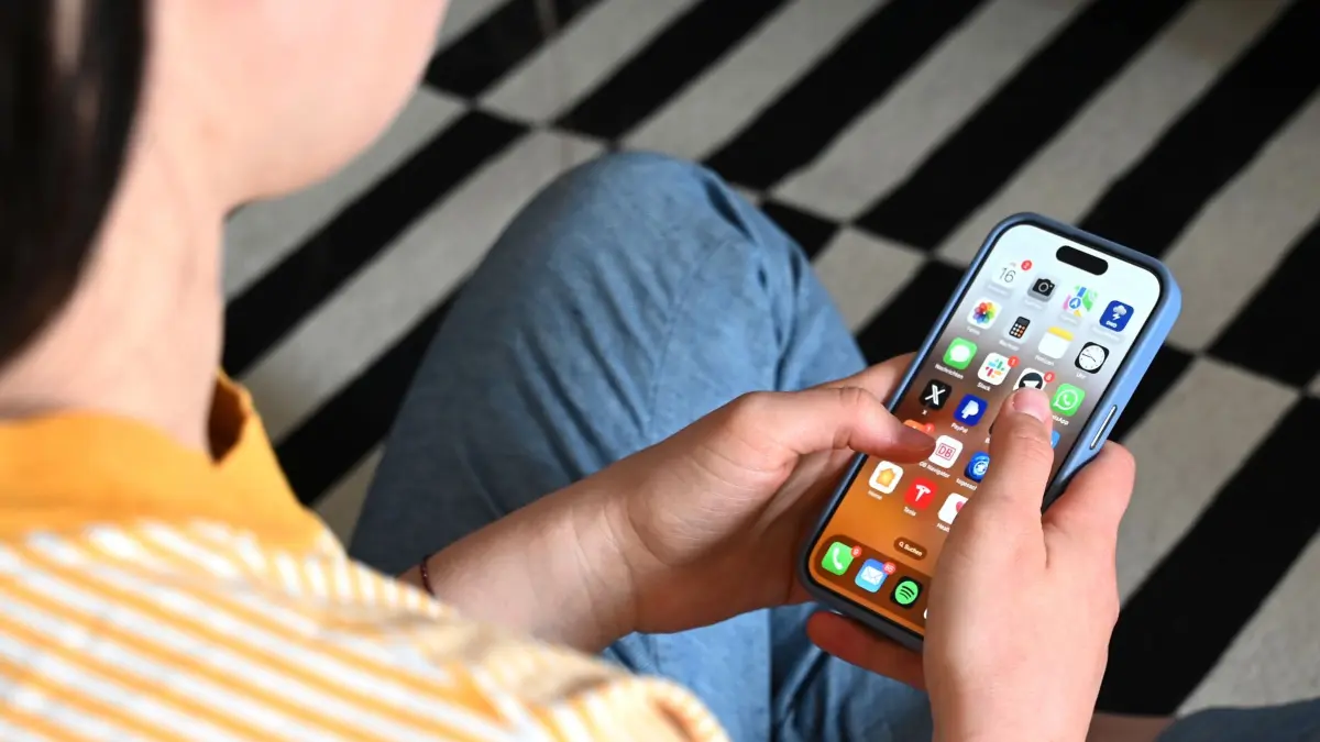 Smartphone-Nutzung bei Jugendlichen: SYMBOLBILD - 17.05.2025, Sachsen, Leipzig: Eine Jugendliche sitzt auf dem Boden und nutzt ein Smartphone - auf dem Display sind verschiedene Apps zu sehen. (zu dpa: «Umfrage: Vertrauen in Nachrichten trotz Social Media stabil») Foto: Elisa Schu/dpa +++ dpa-Bildfunk +++