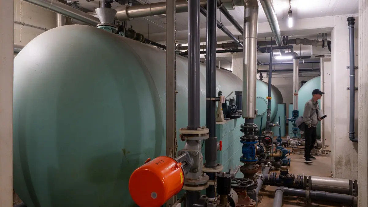 Pressetermin im Atombunker Pankstraße: 16.06.2026, Berlin: Ein Medienvertreter steht während eines Pressetermins des Berliner Unterwelten e.V. zwischen den Kesseln des Wasserwerkes im Atombunker Pankstraße. In einer neuen 90-minütigen Tour des Vereins sollen unter dem Motto «Zivil- und Katastrophenschutz vom Kalten Krieg bis heute» kleine Besuchergruppen durch die Räume der zu großen Teilen original ausgestatteten Zivilschutzanlage geführt werden. Foto: Soeren Stache/dpa +++ dpa-Bildfunk +++