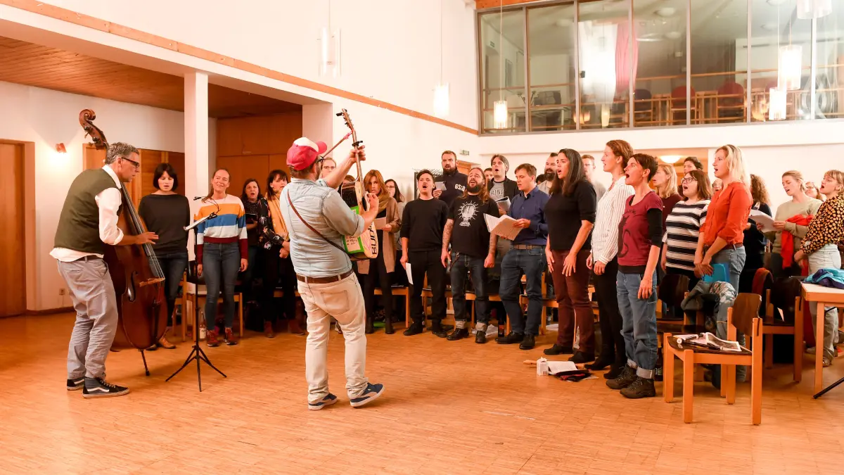 01.10.2018, Bayern, München: Der Chorleiter Dominik Schauer (M) spielt bei einer Probe Gitarre während die Mitglieder des "Bud-Spenzer-Heart-Chor" singen. Der Chor versteht sich als Spaß- und Freizeitprojekt und singt nur Lieder aus den Filmen von Bud Spencer. (zu dpa-Korr "Kein Männermangel: Chor singt (fast) nur Bud-Spencer-Musik" vom 04.10.2018) Foto: Tobias Hase/dpa +++ dpa-Bildfunk +++