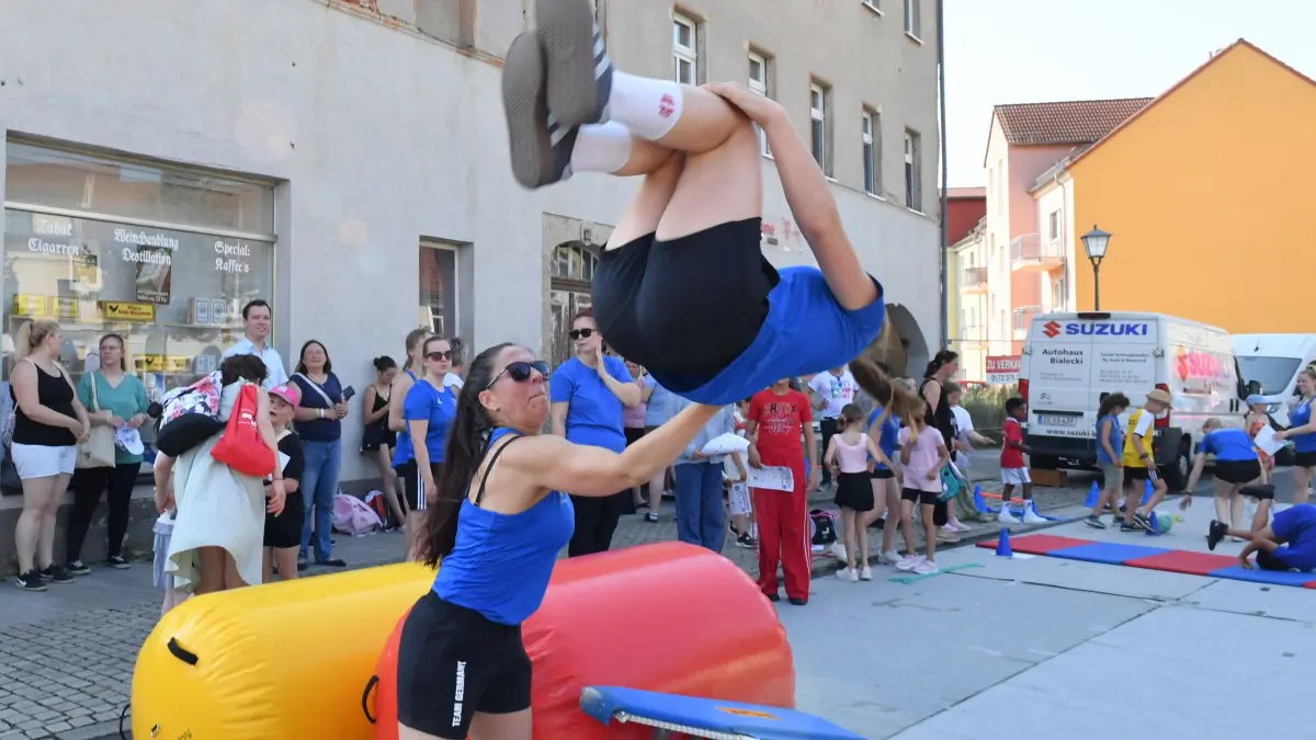 Das seit 1953 existierende TSC-Sportensemble Elsterwerda zum Beispiel betreibt bei dem Sportfest einen flächenmäßig riesigen Stand auf dem Marktplatz, mit einem eigenen Stationsbetrieb. Allein im Sportensemble trainieren über den Schulsport hinaus ca. 220 Kinder und Jugendliche. Das hier zelebrierte Turnen trainiere die körperliche und geistige Leistungsfähigkeit, die sich auf das gesamte Leben auswirke, meint Chef-Trainerin Nancy Beilich.