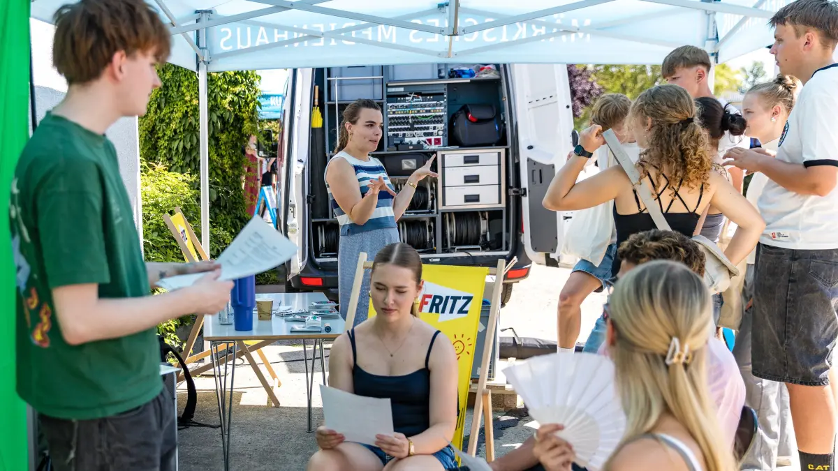 Newscamp Brandenburg: Schüler sprechen sich an einem Stand des rbb im Rahmen des Newscamp Brandenburg für die Produktion eines Podcasts ab.