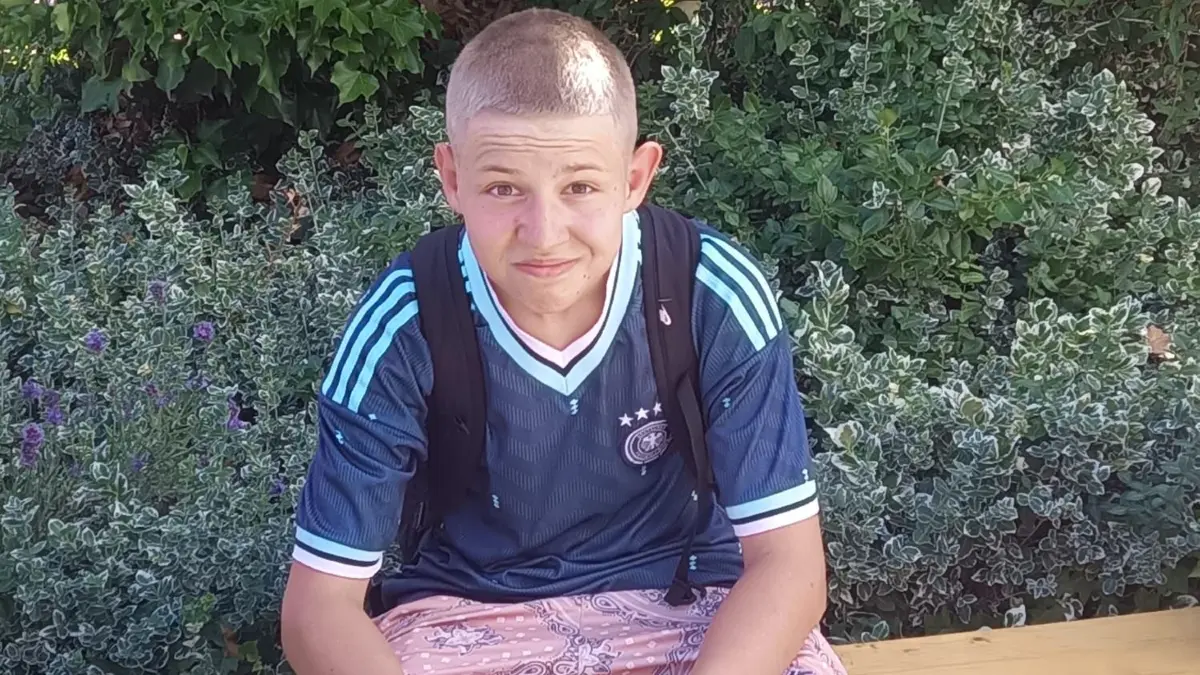 Oskar von der Spreewald-Schule in Lübben chillt mit seinem Deutschlandtrikot auf einer Bank im Schatten. Er wurde nach seiner Meinung zur WM gefragt.