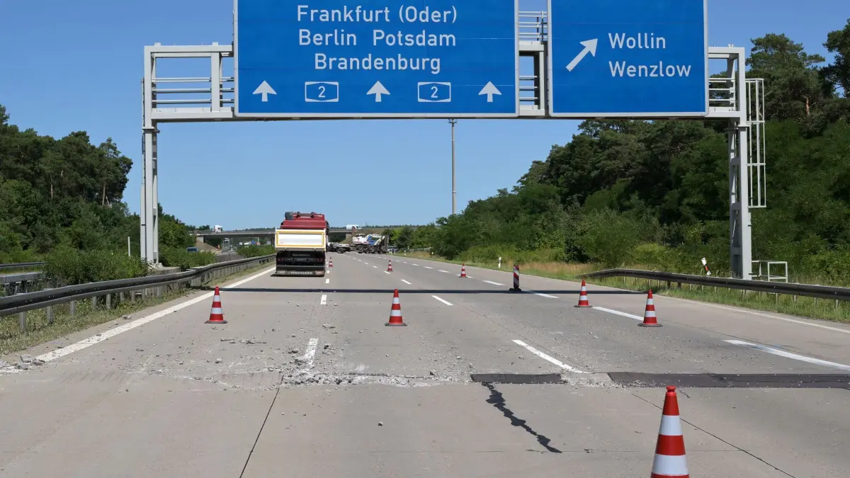 Hitze in Deutschland - Straßenschäden A2 in Brandenburg: 26.06.2026, Brandenburg, Wollin: Wenige Meter vor der Abfahrt Wollin der Autobahn 2 (2) in Richtung Berlin haben sich Teile der Betonfahrbahn gegeneinander geschoben, im Vordergrund liegen aufgebrochene Betonbrocken neben der Fahrspur. Durch den Druck bei den hohen Temperaturen der derzeitigen Hitzewelle zerbrachen die Betonplatten an den Übergängen, Betonteile wurden zum Teil mehrere Meter weit geschleudert; zahlreiche Fahrzeuge, die über die Stelle fuhren, wurden beschädigt. Foto: Michael Bahlo/dpa +++ dpa-Bildfunk +++