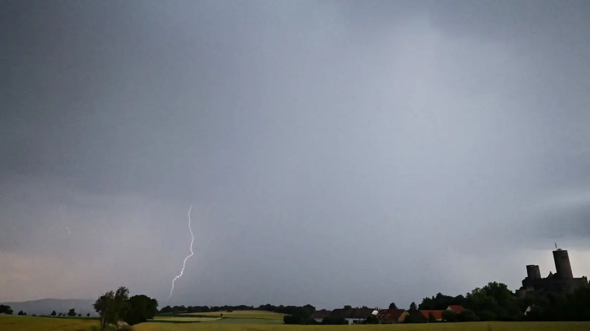 Hitze in Deutschland - Gewitter über Hessen: ARCHIV - 21.06.2026, Hessen, Münzenberg: Ein Blitz leuchtet vor dunklen Gewitterwolken über der Burgruine Münzenberg. (zu dpa: «Nach der Hitze drohen Gewitter») Foto: Florian Wiegand/dpa +++ dpa-Bildfunk +++