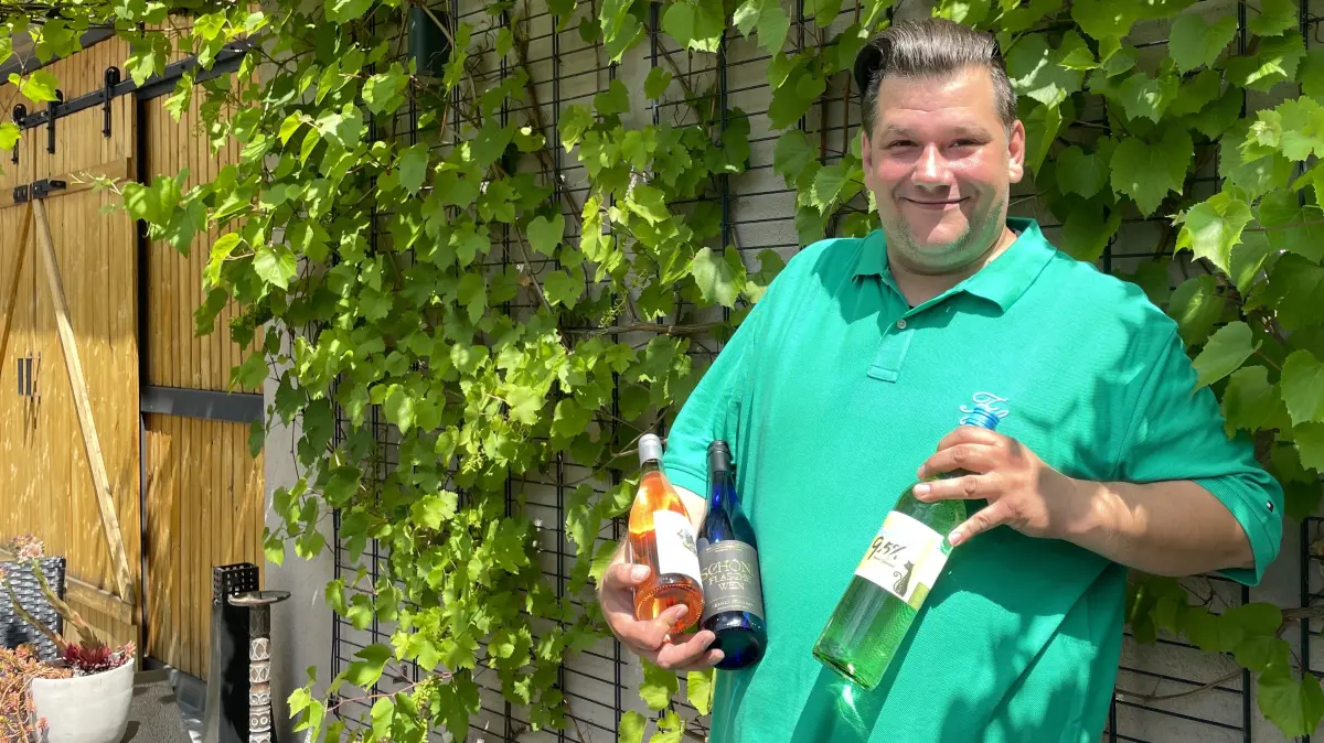 Sebastian Schulz von Wein Schulz Spremberg hält am 25.06.2026 Sommerweine auf seiner Terrasse in die Kamera.