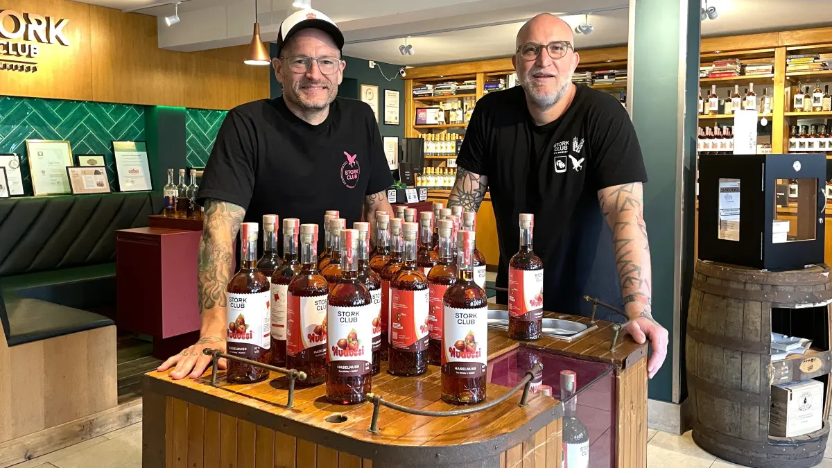 Die Chefs der Stork Club Whiskey Destillerie, Bastian Heuser (l.) und Steffen Lohr (l.), stehen am 01.07.2026 in ihrem Verkaufsraum in Schlepzig vor einem Tisch mit Nudossi-Whiskey.