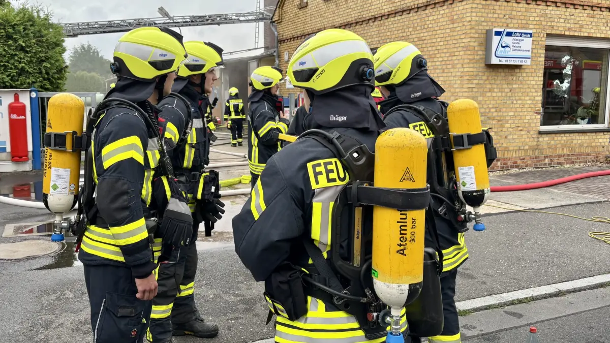 Unter Atemschutz gehen die Feuerwehrleute in die Werkstatt in Schleife, um den Brand löschen zu können.