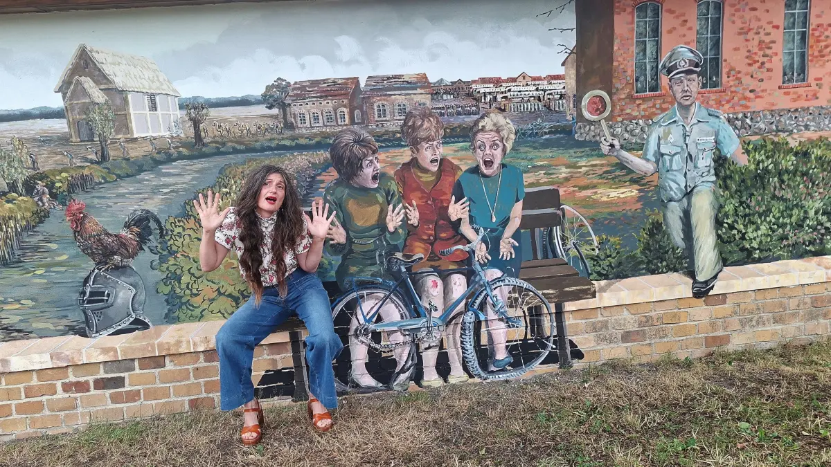 Mit ihrem neuen Wandbild mitten in Dollenchen (Elbe-Elster) erzählt Stephanie Mai Dorfgeschichten, Legenden und Erinnerungen – darunter auch eine Szene mit drei jungen Frauen aus den 1970er-Jahren.