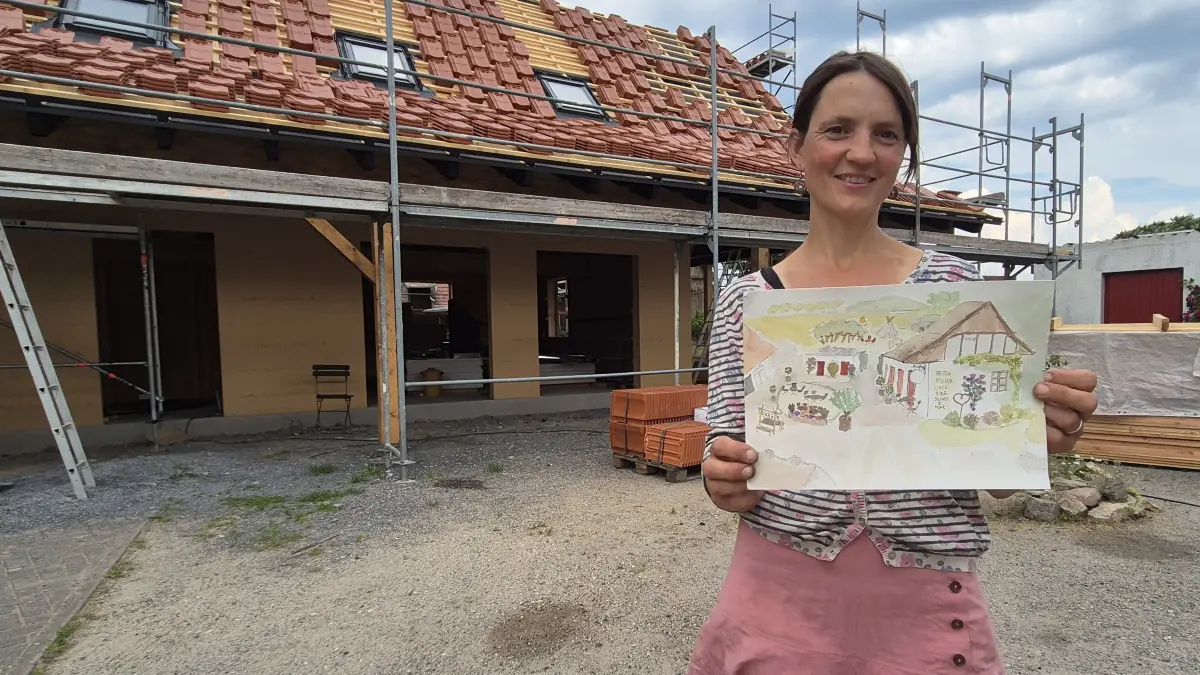 Urte Henkert-Jörgensen mit einem Aquarell vor dem künftigen Hofcafé in Klein Oelsa (Ortsteil von Boxberg).