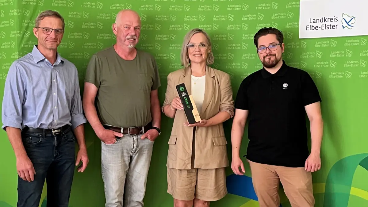 Der Landkreis präsentiert den neuen EE‑Wert‑Preis für Klimaanpassung: Von links stehen Klimaschutzmanager Holger Krüger, Sachgebietsleiter Klaus Oelschläger, Marketingkoordinatorin Janine Niederstraßer mit dem EE‑Wert‑Preis in der Hand sowie Social‑Media‑Mitarbeiter Philipp Strelitz.