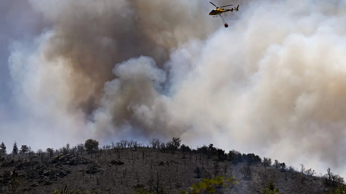 Waldbrände in Südfrankreich: 05.07.2026, Frankreich, Trévillach: Ein Löschhubschrauber wirft Wasser auf einen Waldbrand in der Nähe des Col des Auzines bei Trévillach ab. Ein Waldbrand brach am 4. Juli in einem schwer zugänglichen Gebirgsmassiv in der Nähe von Trévillach aus. Foto: Matthieu Rondel/AFP/dpa +++ dpa-Bildfunk +++