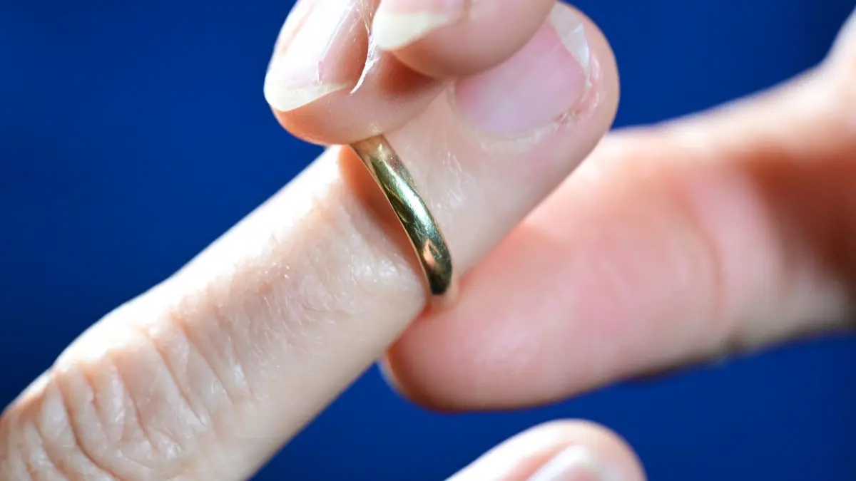 Scheidung: PRODUKTION - 10.06.2026, Baden-Württemberg, Stuttgart: Eine Frau zieht sich ihren Ehering vom Ringfinger (gestellte Szene und Symbolbild). (zu dpa: «Zahl der Scheidungen in MV um 7,1 Prozent gesunken») Foto: Bernd Weißbrod/dpa +++ dpa-Bildfunk +++