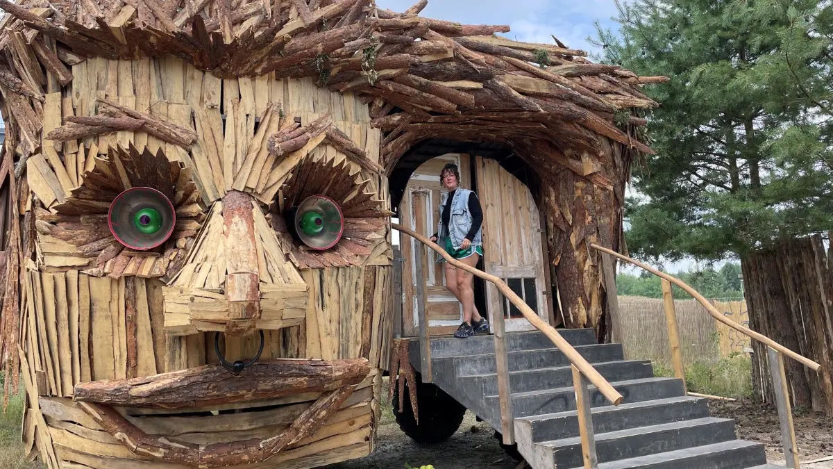 Eine besonders freundliche Einladung zum Friseur spricht Kira Taige, Geschäftsführerin des Feel Festivals, vor diesem Schmuckstück gestalterischer Holzkunst aus.