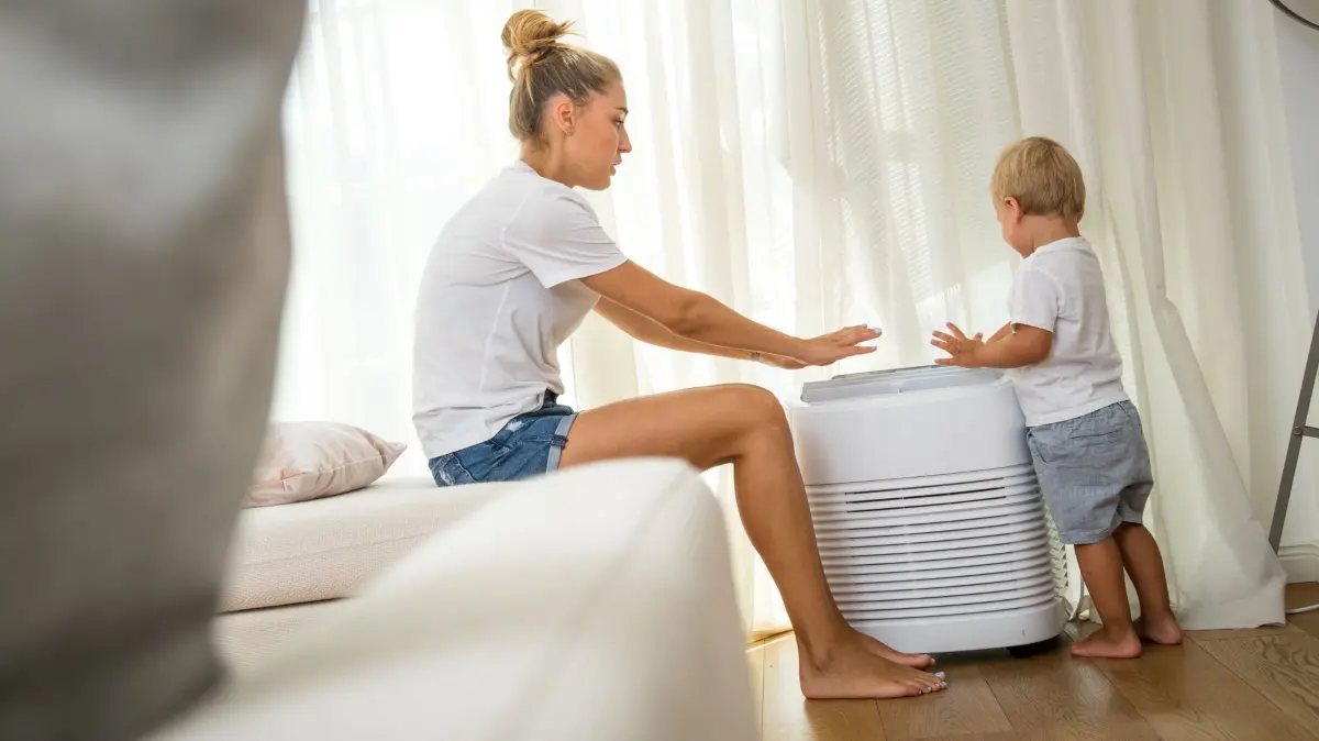 Mutter und Sohn vor einer mobilen Klimaanlage