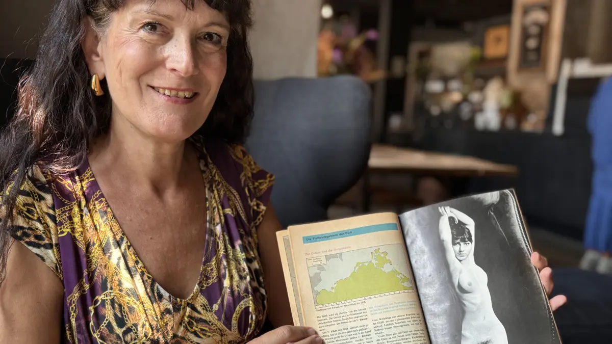 Die Cottbuserin Kathleen Hubrich im Sommer 2026 mit ihrem Geografiebuch von 1980.