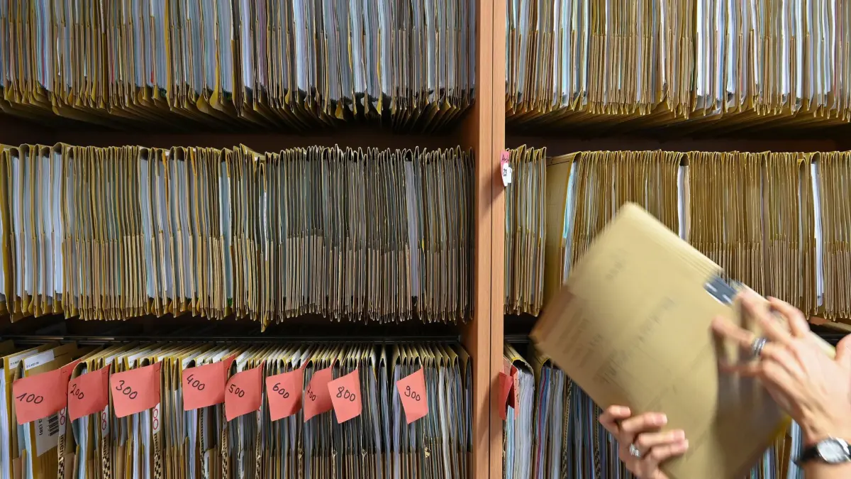 Bürokratie: ARCHIV - 27.07.2023, Hessen, Frankfurt/Main: Eine Mitarbeiterin einer Behörde greift an einem Regal nach einer Akte. (zu dpa: «Voigt will Vorschriften entrümpeln - zweites Gesetz geplant») Foto: Arne Dedert/dpa +++ dpa-Bildfunk +++