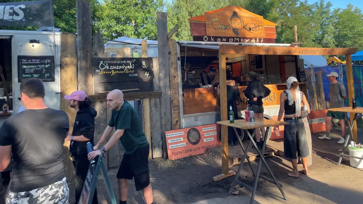 Zwischen Bass und Bratplatte arbeiten zwei Berlinerinnen am Okonomiyaki-Stand beim Feel Festival.