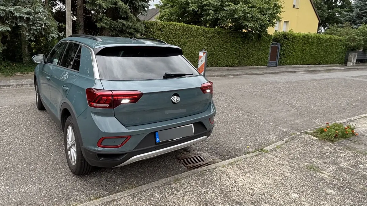 Eine Anwohnerin des Anglerwegs in Ruhland fürchtet um ihr Auto. Seit Wochen machen zwei Hindernisse die Einfahrt in das eigene Grundstück zur Mutprobe. Rechts neben dem Auto eine Warnbake, direkt am Bordstein ein eingebrochener Regenwassereinlauf.